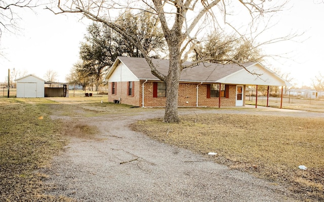 view of front of house with a storage unit and a carport