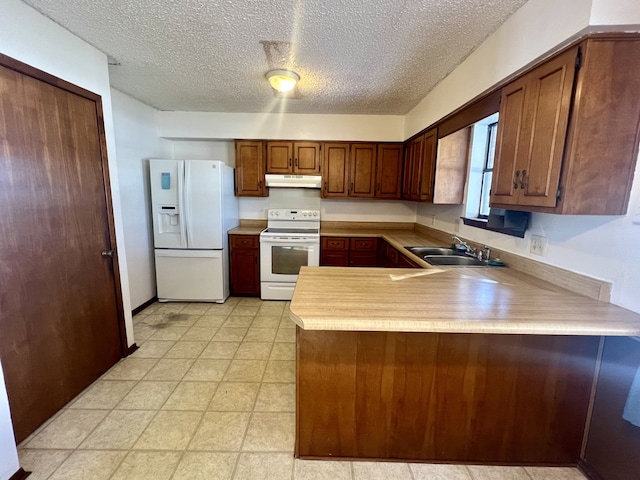 kitchen featuring kitchen peninsula, a textured ceiling, white appliances, and sink