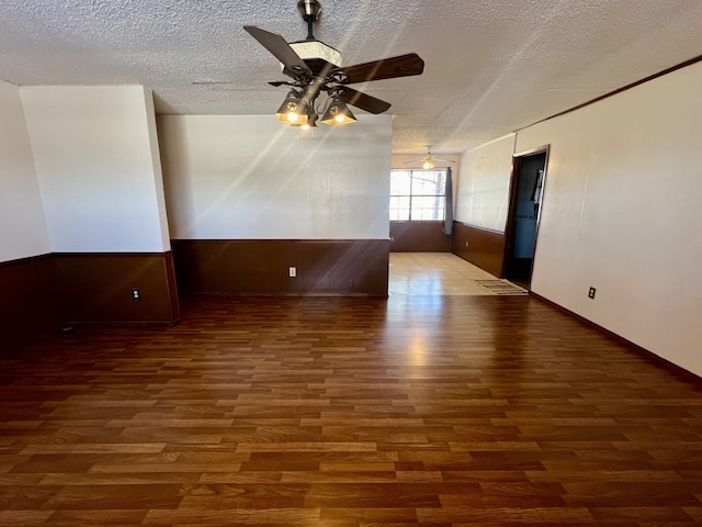 spare room with ceiling fan, dark wood-type flooring, and a textured ceiling