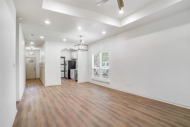 unfurnished living room with ceiling fan and light hardwood / wood-style floors