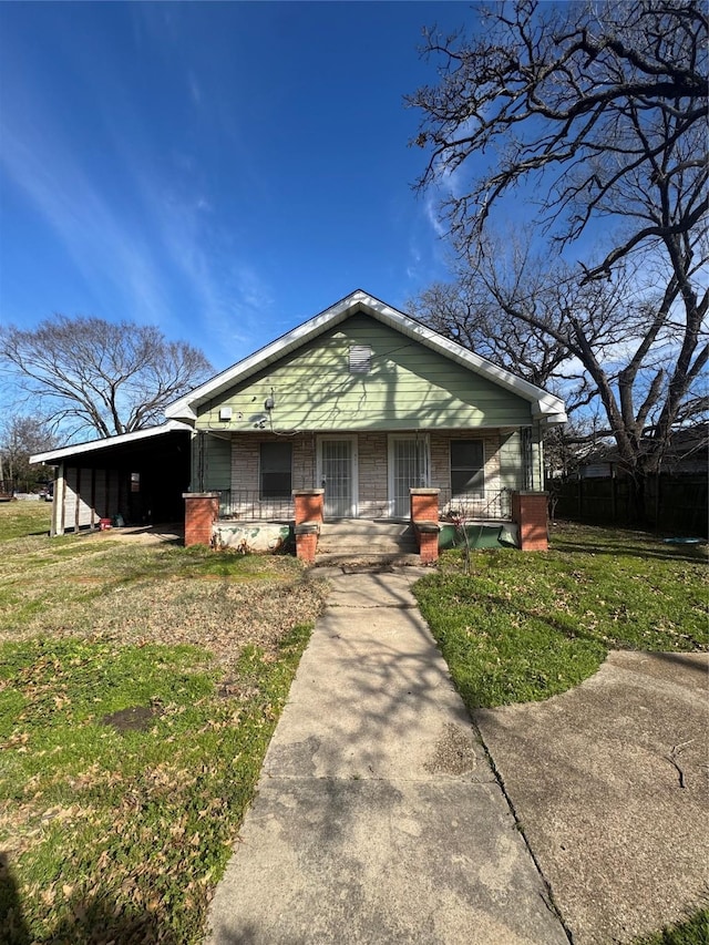 view of front of house with a carport, a porch, and a front lawn