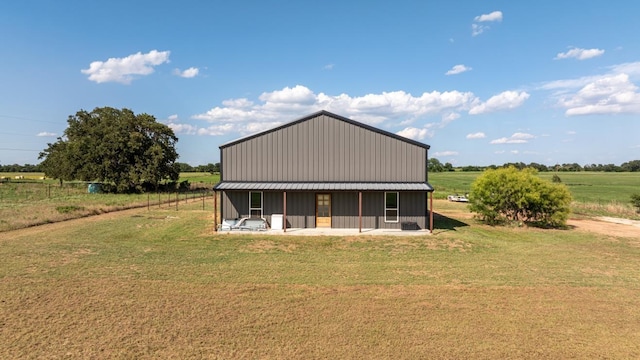 back of house featuring a lawn and a rural view