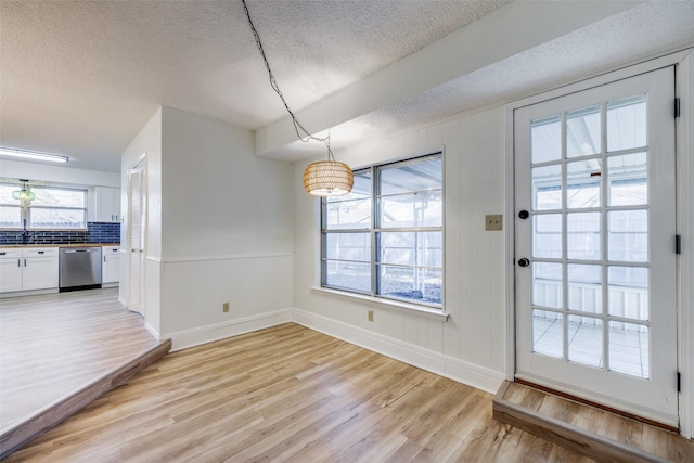 interior space with sink, a textured ceiling, and light wood-type flooring