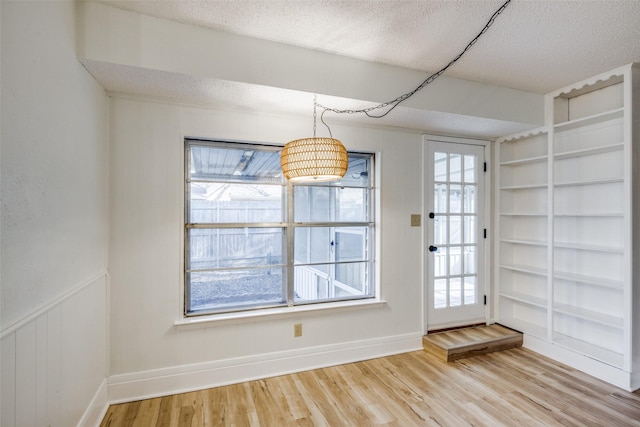 interior space featuring a textured ceiling, hardwood / wood-style flooring, and built in features