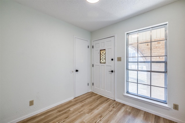 entryway featuring a textured ceiling and light wood-type flooring