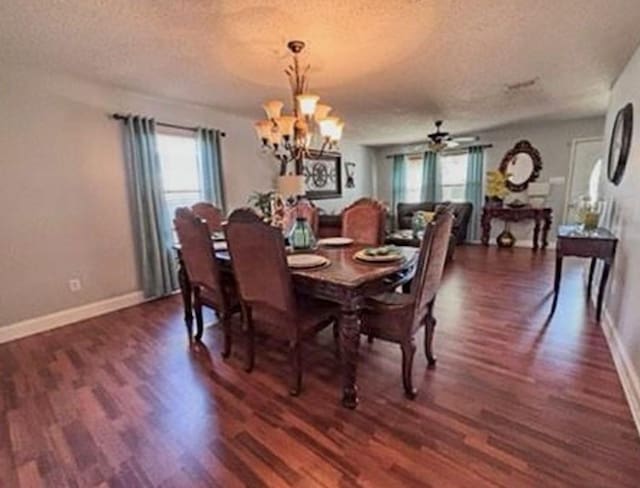 dining space with a textured ceiling, dark hardwood / wood-style flooring, and ceiling fan with notable chandelier