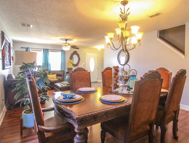 dining room featuring ceiling fan with notable chandelier, wood-type flooring, and a textured ceiling