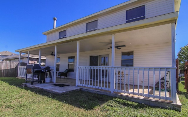 rear view of house featuring ceiling fan and a yard