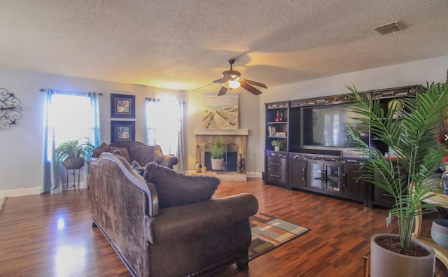 living room featuring a textured ceiling, ceiling fan, and dark wood-type flooring