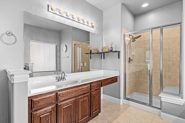 bathroom with tile patterned flooring, vanity, and walk in shower