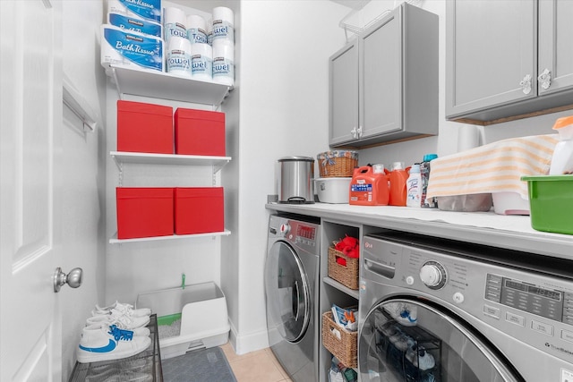 washroom with cabinets, independent washer and dryer, and light tile patterned floors