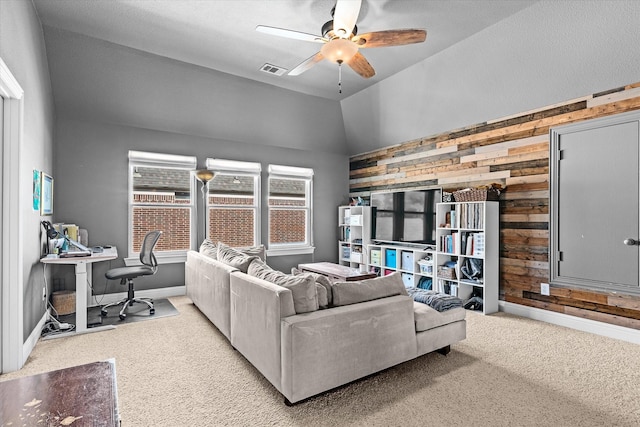 carpeted living room with wooden walls, ceiling fan, and lofted ceiling