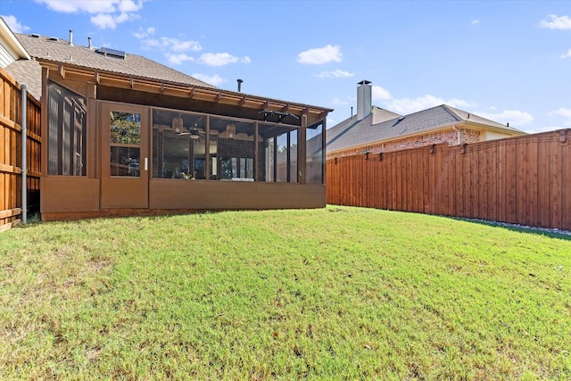 view of yard with ceiling fan and a sunroom