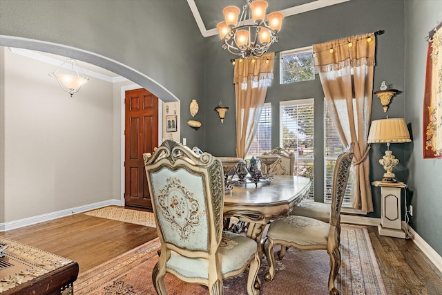 dining space with a notable chandelier, dark hardwood / wood-style floors, and crown molding