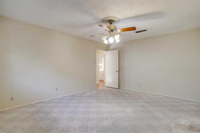 empty room featuring a textured ceiling, ceiling fan, and light carpet