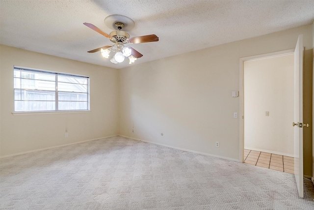 unfurnished room with ceiling fan, light colored carpet, and a textured ceiling