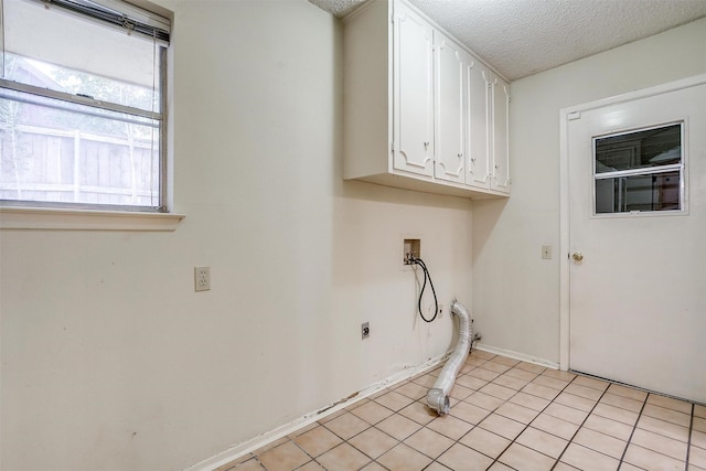 clothes washing area featuring hookup for an electric dryer, cabinets, a textured ceiling, and washer hookup