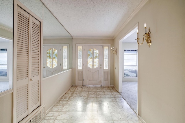 entrance foyer with a textured ceiling and ornamental molding