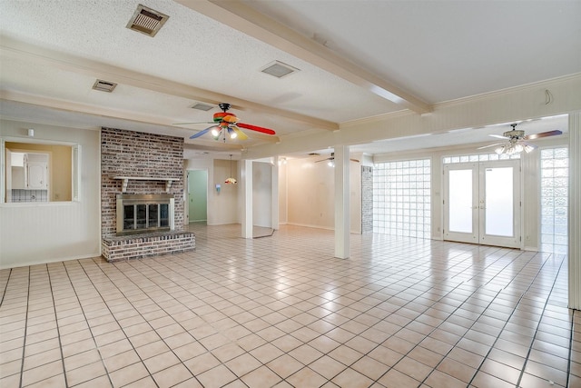 unfurnished living room featuring french doors, a fireplace, a textured ceiling, ceiling fan, and beamed ceiling