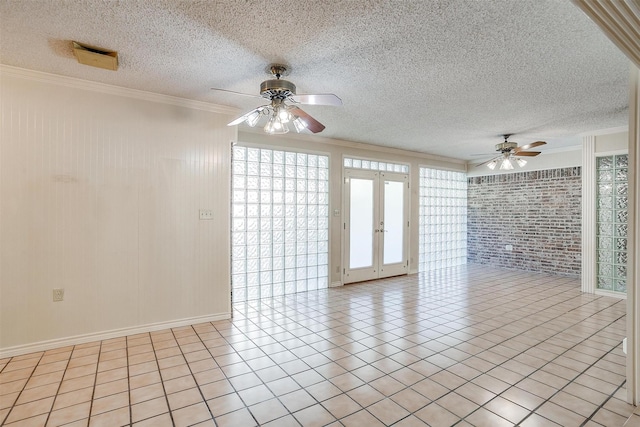 tiled spare room with french doors, ornamental molding, brick wall, a textured ceiling, and ceiling fan