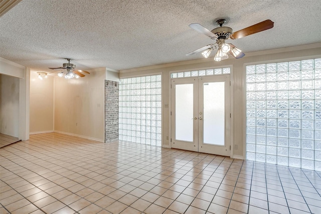 spare room featuring a textured ceiling, light tile patterned floors, and crown molding