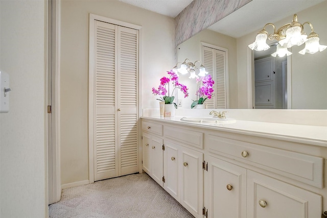 bathroom with a notable chandelier and vanity