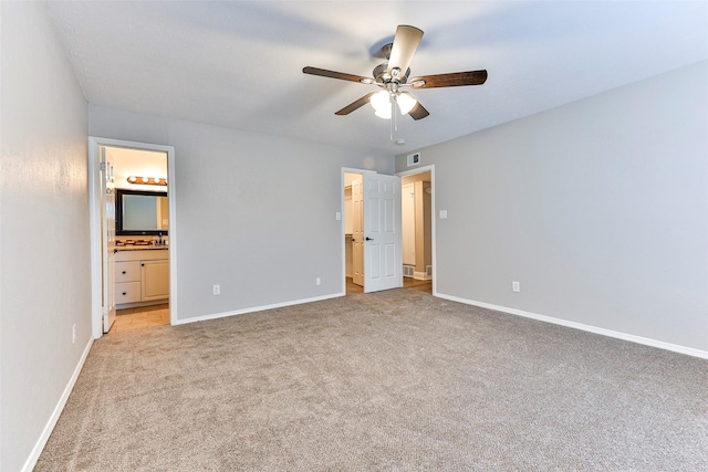 unfurnished bedroom with light carpet, ensuite bathroom, and ceiling fan