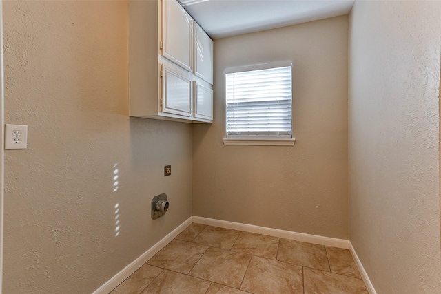 laundry area with cabinets, light tile patterned floors, and hookup for an electric dryer