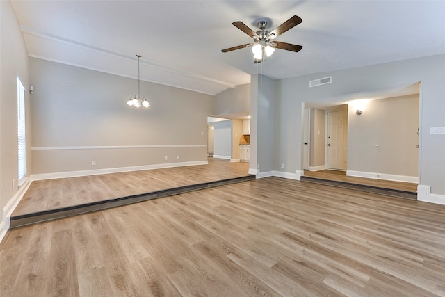 unfurnished living room with ceiling fan with notable chandelier, light wood-type flooring, and lofted ceiling