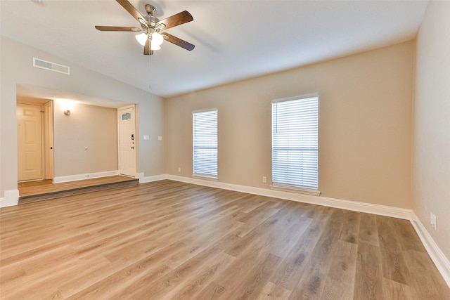 spare room with ceiling fan, light wood-type flooring, and vaulted ceiling