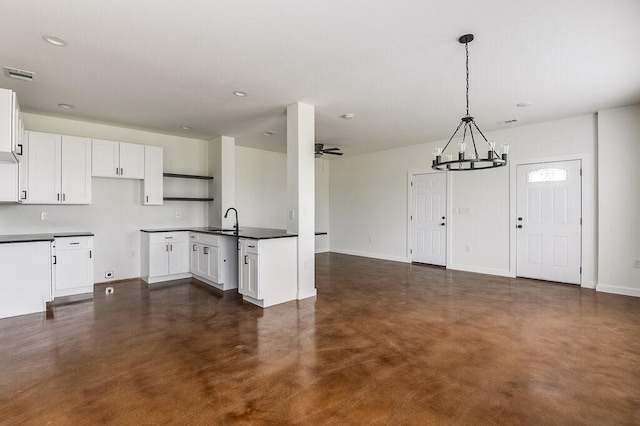 kitchen featuring sink, white cabinets, decorative light fixtures, and ceiling fan with notable chandelier