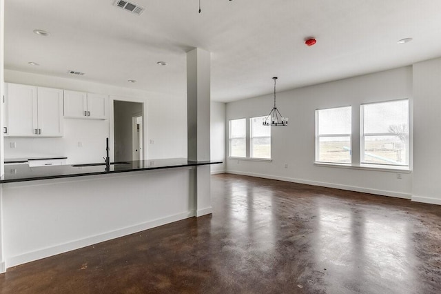 kitchen featuring white cabinets, decorative light fixtures, an inviting chandelier, and sink