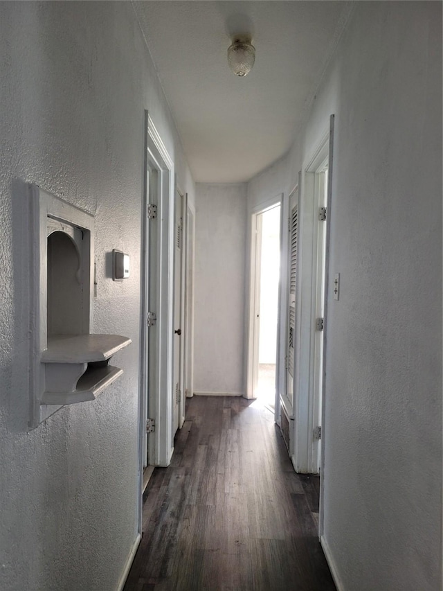 corridor featuring dark wood-type flooring