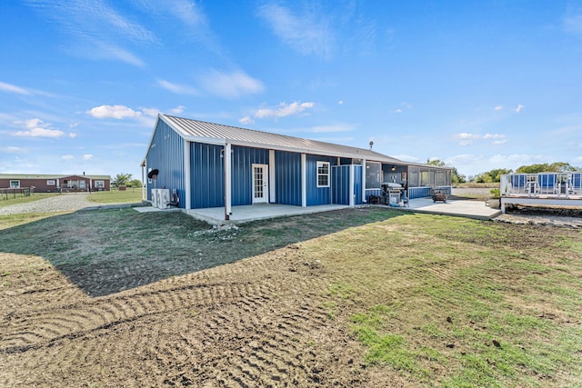 back of property with a yard and a patio