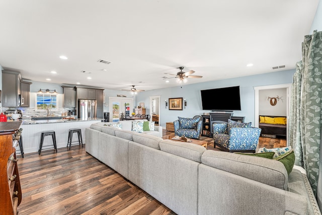 living room with ceiling fan and dark hardwood / wood-style floors