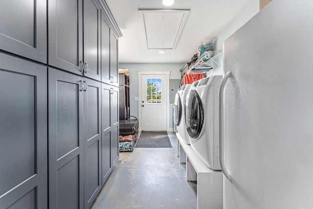 clothes washing area featuring cabinets and washing machine and dryer