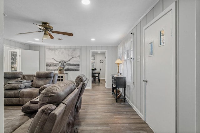 living room featuring hardwood / wood-style flooring, ceiling fan, and crown molding