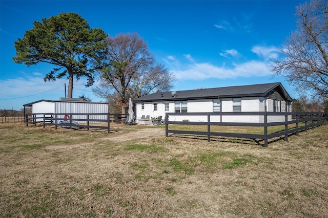 back of house with an outbuilding and a yard