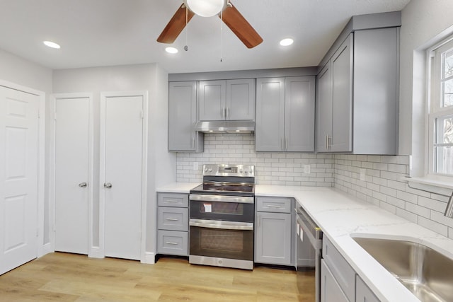 kitchen with gray cabinetry, sink, stainless steel appliances, and light hardwood / wood-style floors