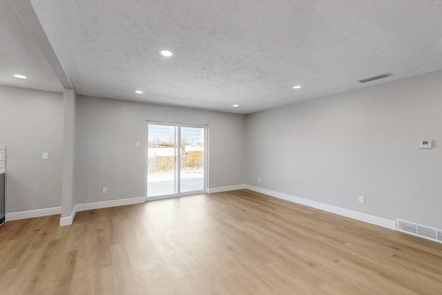 empty room featuring light hardwood / wood-style floors and a textured ceiling