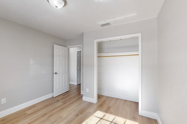 unfurnished bedroom with a closet and light hardwood / wood-style flooring