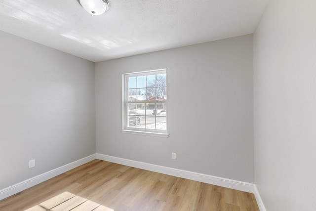 unfurnished room featuring light hardwood / wood-style floors and a textured ceiling