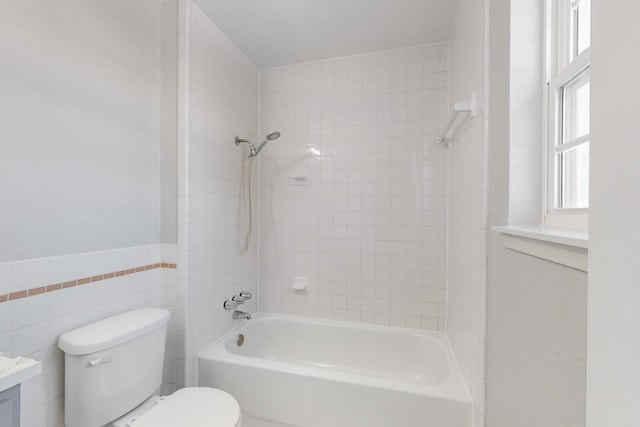 full bathroom with vanity, tiled shower / bath, tile walls, and toilet