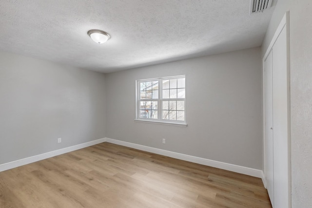 unfurnished bedroom featuring a textured ceiling and light hardwood / wood-style flooring