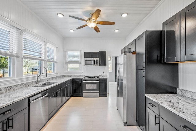 kitchen featuring sink, ceiling fan, stainless steel appliances, crown molding, and light stone countertops