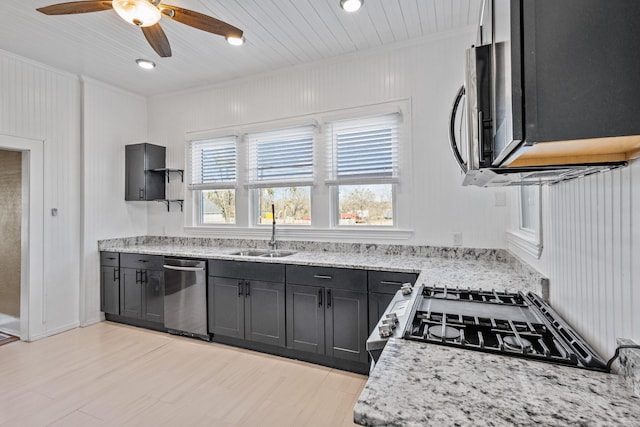 kitchen with light stone counters, sink, a wealth of natural light, and appliances with stainless steel finishes