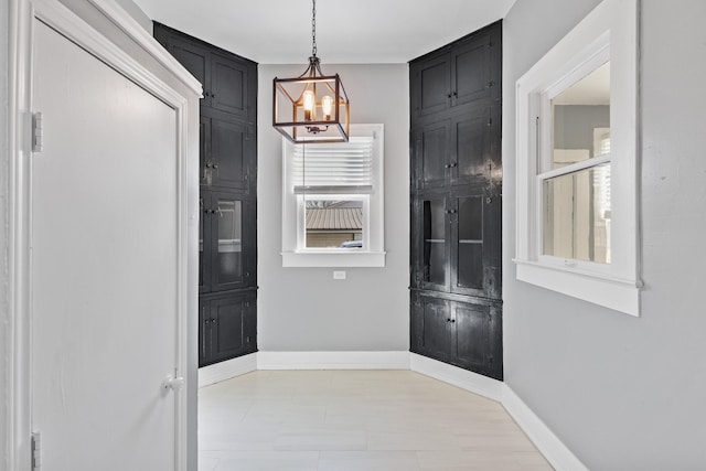 doorway to outside featuring an inviting chandelier