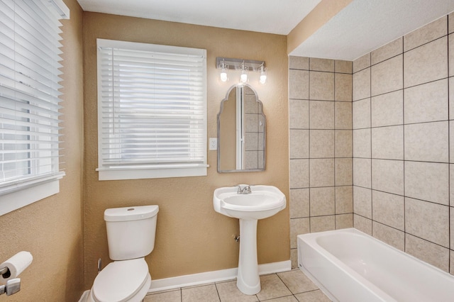 bathroom with toilet, tile patterned flooring, and a washtub