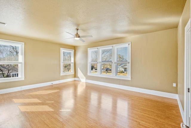 spare room featuring hardwood / wood-style flooring, ceiling fan, and a textured ceiling