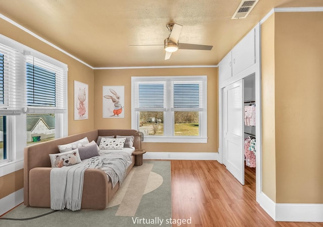 sitting room featuring crown molding, a textured ceiling, ceiling fan, and light wood-type flooring